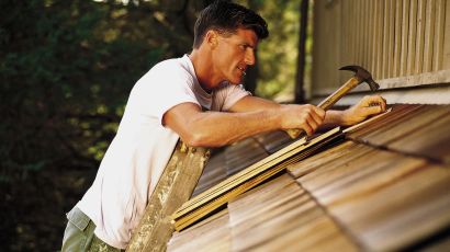 man patching roof