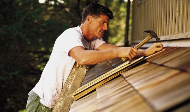 man patching roof