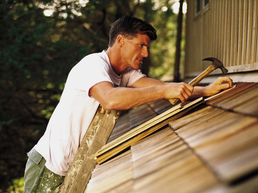 man patching roof