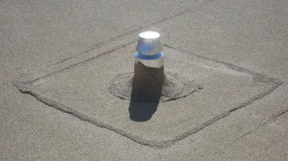 Vent pipe and flashing patch on a granule-surfaced flat roof